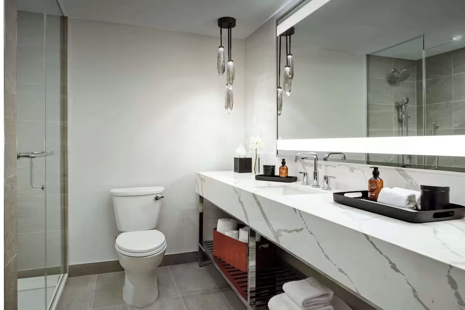 Refresh in a sleek bathroom with glass shower enclosure.