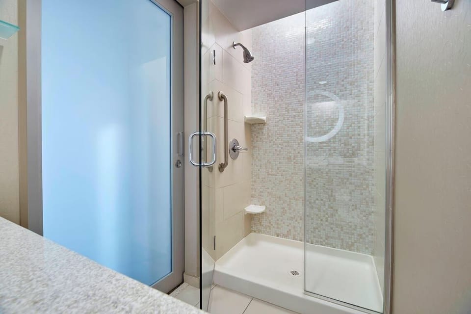 Rinse off in a spotless glass shower with strong water flow.