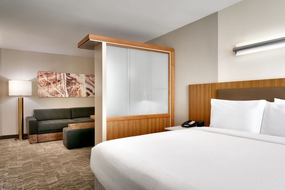 Unwind in crisp linens with a cozy lounge corner nearby.