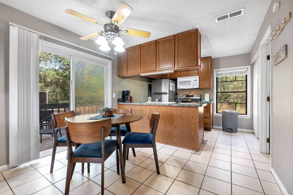 Round walnut dining table seats 4 with additional seats found on the deck outside.