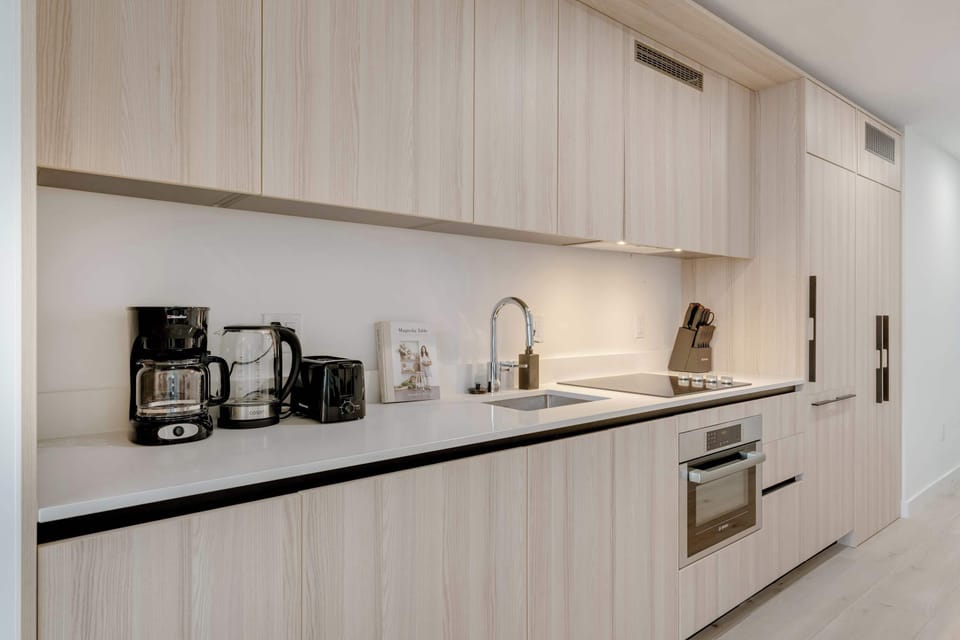 Modern  and completely prepared. A fully stocked chef’s kitchen featuring sleek cabinetry and premium appliances