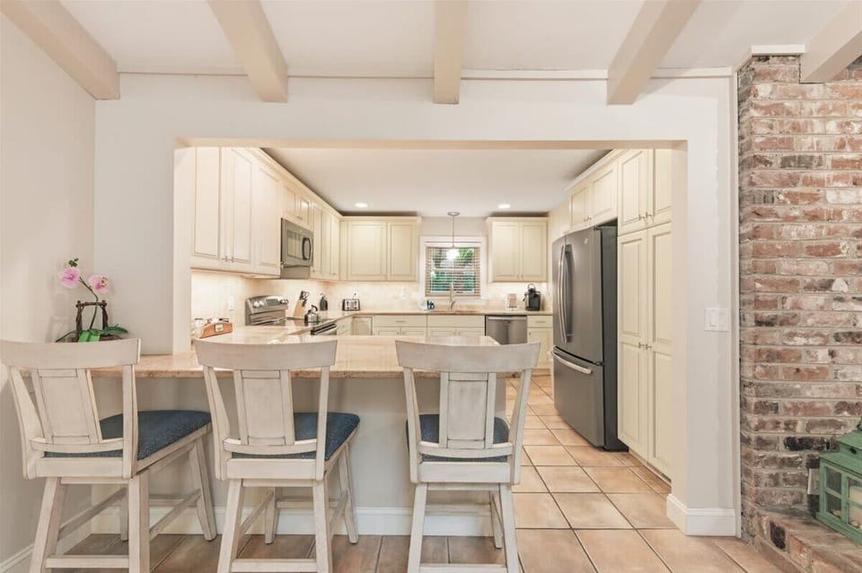 Spacious granite countertops with a stylish tiled backsplash and built-in breakfast bar seating.