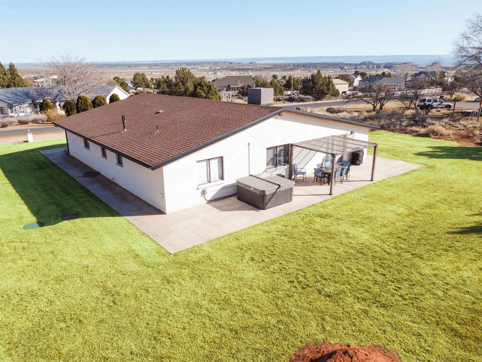 The large yard, covered pergola, and private hot tub make this space ideal for enjoying the painted sunsets or starry skies.