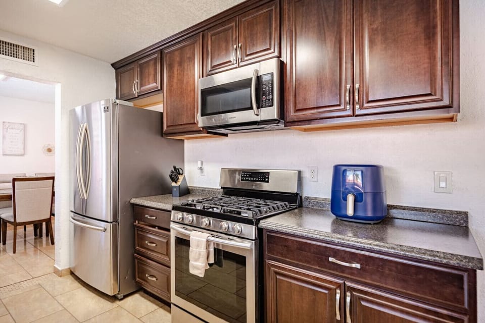 Fully equipped modern kitchen with stainless steel appliances and granite countertops - perfect for preparing family meals.