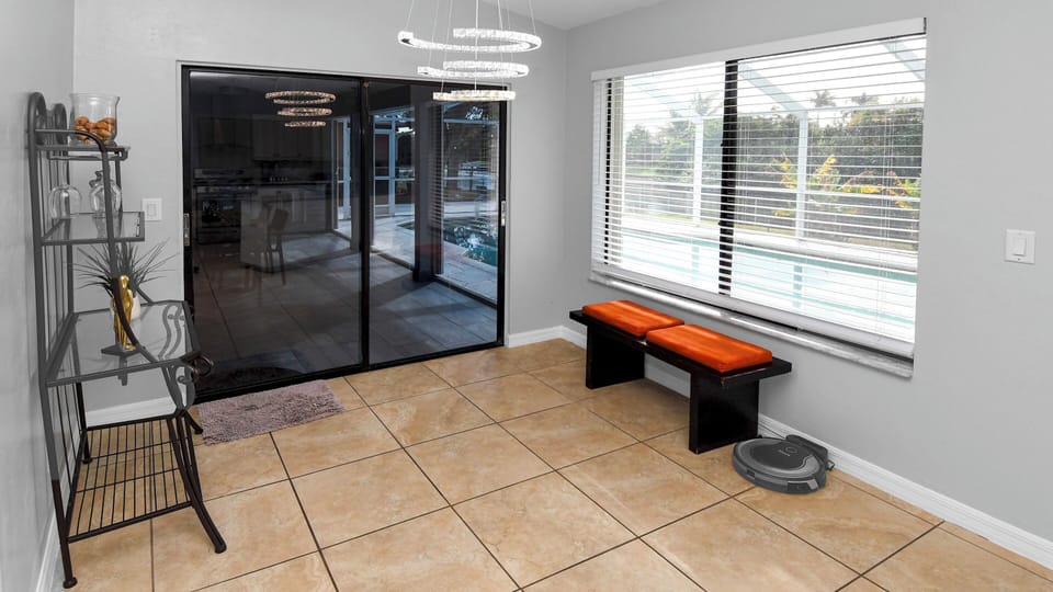Bright transitional area with bench seat and direct access to the outdoor kitchen and pool 