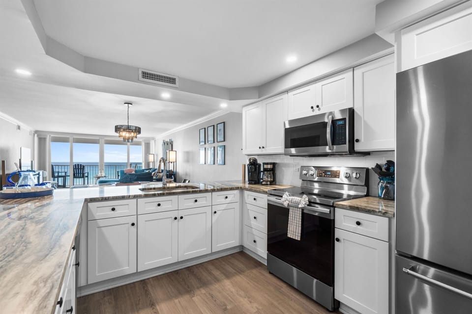 Your fully-equipped kitchen features granite counters, stainless appliances, and stunning ocean views while you cook.