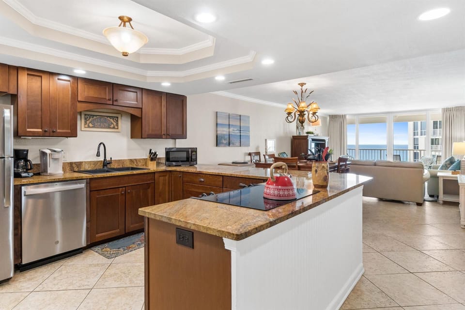 Your spacious kitchen features granite countertops, rich wood cabinetry, and an island perfect for meal prep while enjoying ocean views.