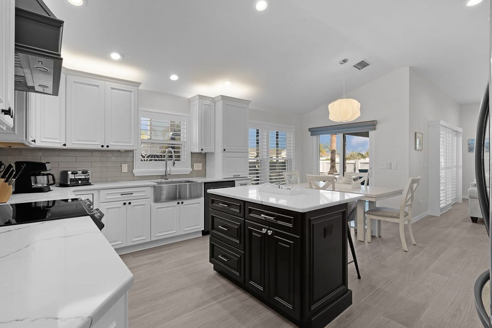 Cook your favorite meals in this bright, spacious kitchen featuring elegant white cabinets, marble countertops, and a convenient island for gathering.