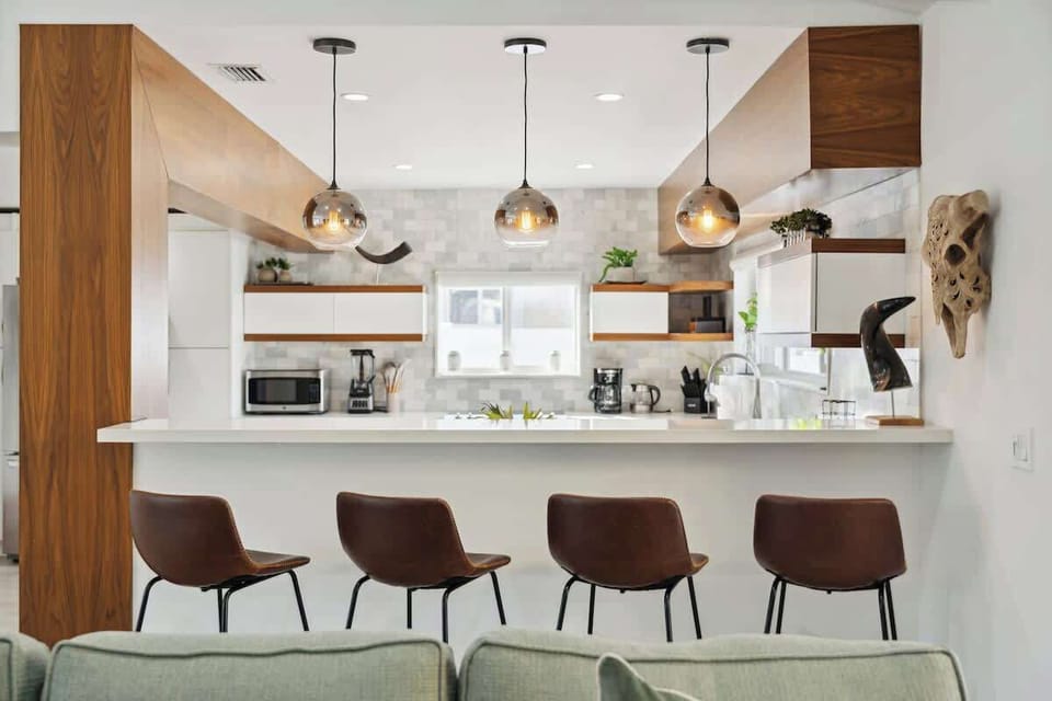 Modern open kitchen with a spacious breakfast bar, comfortable counter seating, and stylish pendant lighting—perfect for casual meals and conversation.
