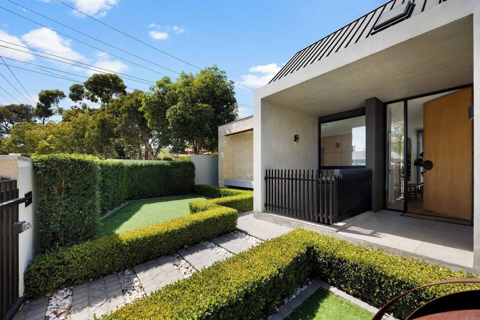 A sleek modern façade and lush landscaping welcome you to this private retreat.