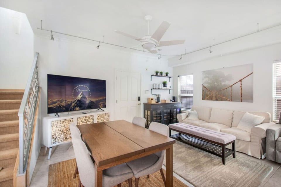 Open living room next to the kitchen, featuring a Smart TV and seating for four at the dining table.
