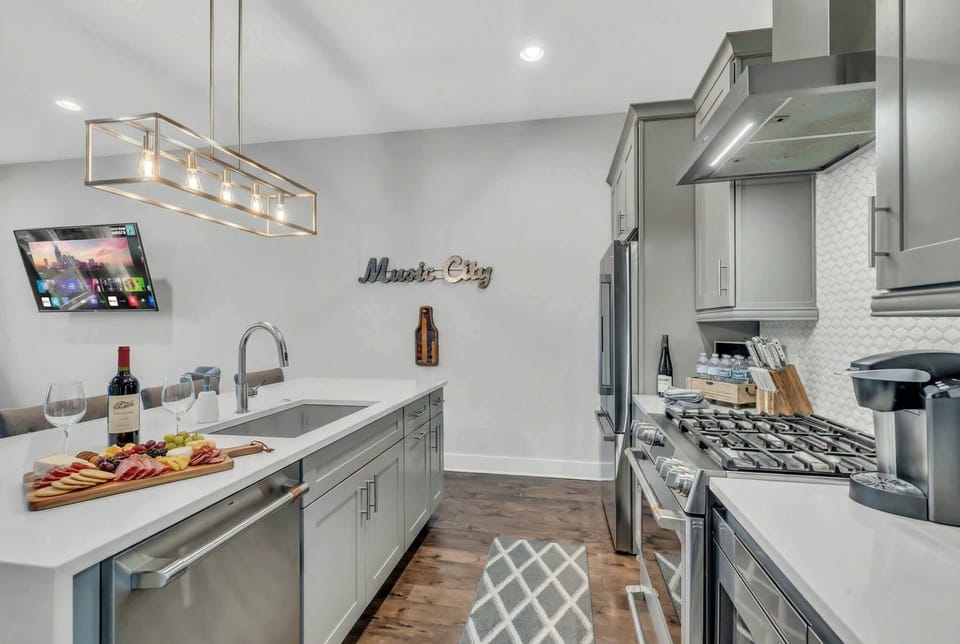 Kitchen island with bar seating, a stove for real cooking, and a TV in view so nobody is stuck chopping vegetables alone. This is where the group lives during their stay