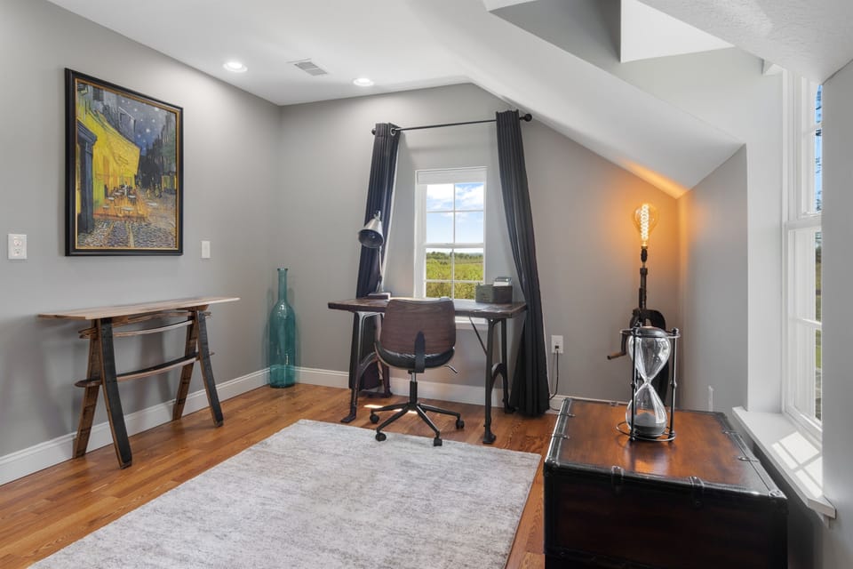 Dedicated desk space with chair and window views.