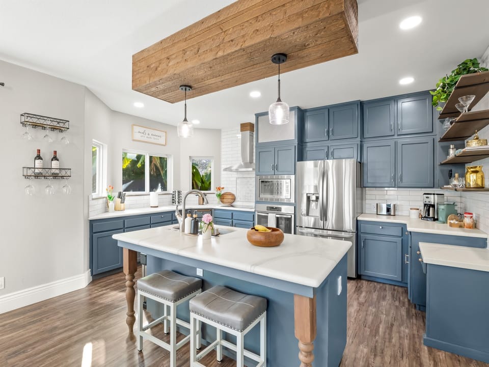 Fully stocked kitchen with stainless steel appliances, spacious island seating, coffee maker, toaster, and all the essentials needed to prepare family meals with ease.