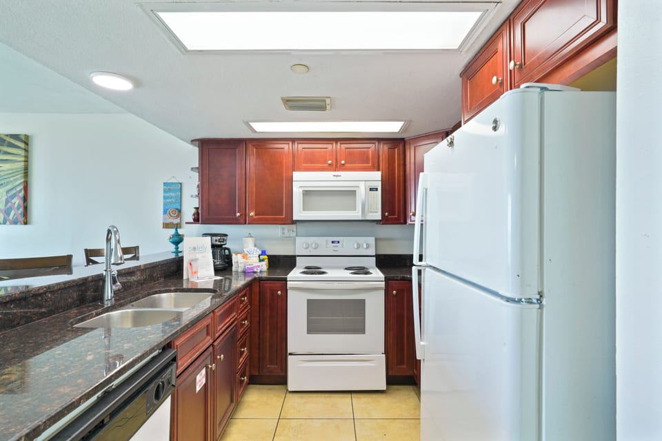 Cook with ease in the Cabana Club 106 kitchen with microwave, dishwasher, and full refrigerator.