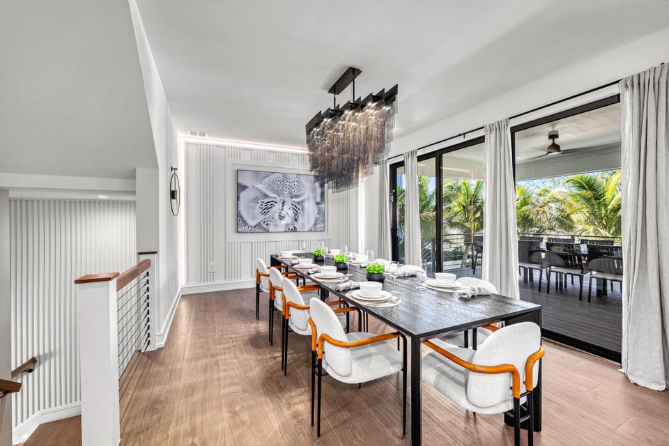 The dining area flows seamlessly to the outdoor living space through sliding glass doors.