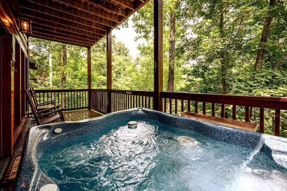Private hot tub on the lower deck, surrounded by trees — an easy way to start the morning or wind down at night.