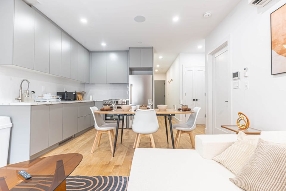 Kitchen with cabinets, stainless appliances, and a dining table with white chairs.