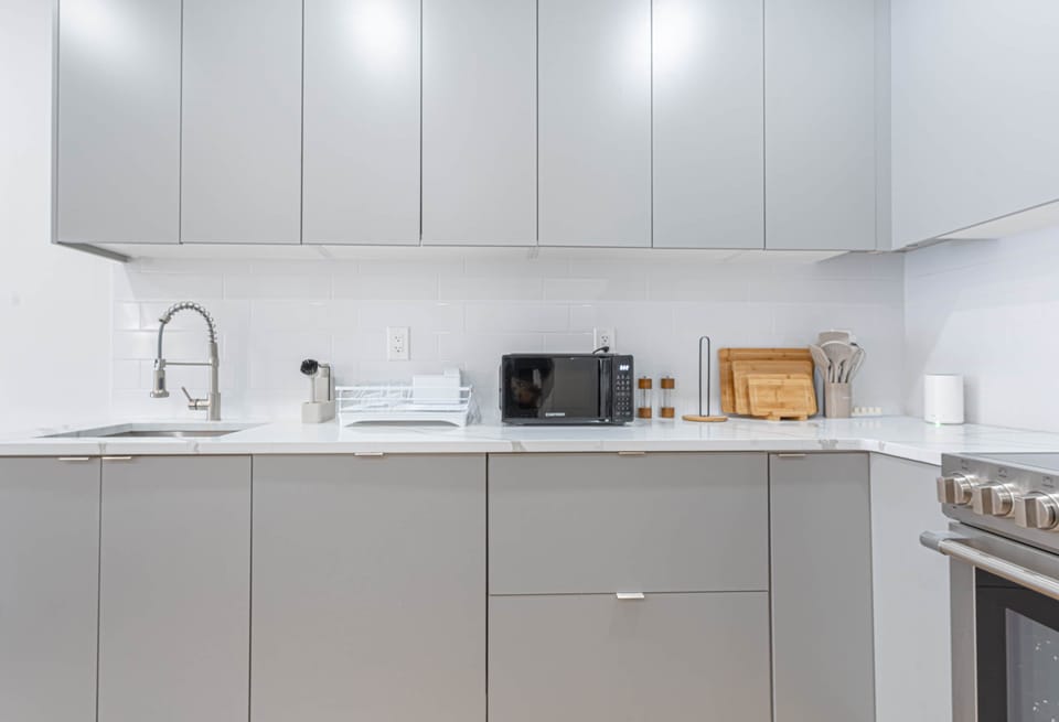 Kitchen counter with a microwave, cutting boards, and oven.