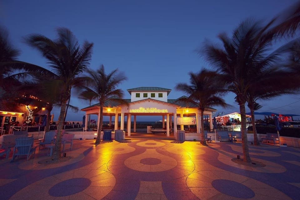 Arrive to a lively, palm-lined entrance glowing at dusk.