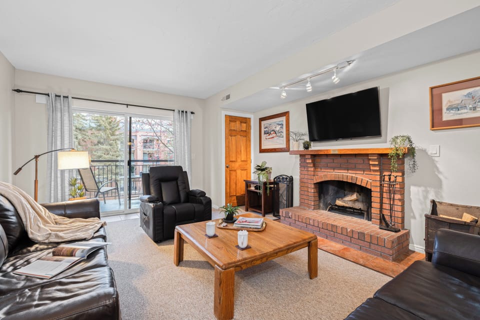 A large flat-screen TV and cozy fireplace setup, perfect for après-ski relaxation.