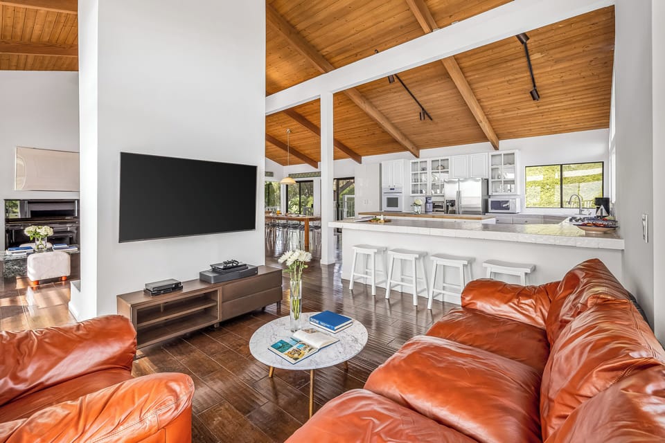 TV lounge with a gaming console and open access to the kitchen.