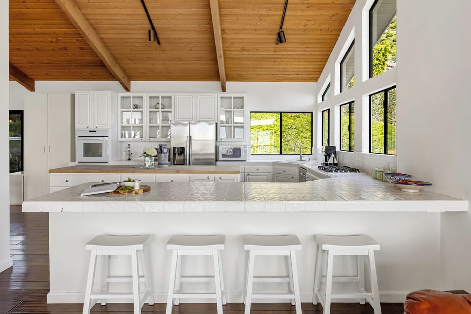 Spacious kitchen with island seating and stainless-steel appliances.