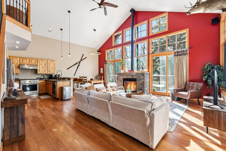 Relax in your spacious living area with soaring ceilings, crackling fireplace, and panoramic forest views through floor-to-ceiling windows.