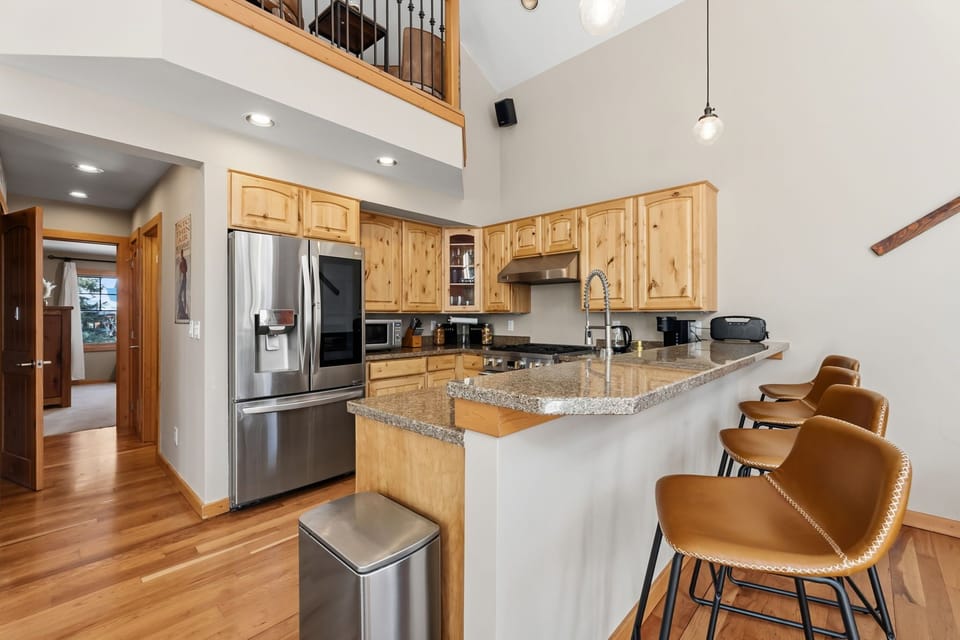 Gather around this spacious granite island where morning coffee and evening conversations flow naturally in your beautifully appointed mountain kitchen.