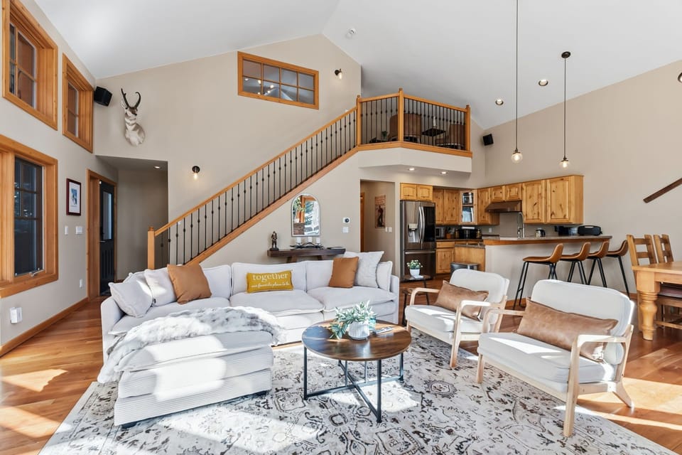 Gather with loved ones in this stunning open-concept space where soaring ceilings and warm wood accents create the perfect mountain retreat atmosphere.