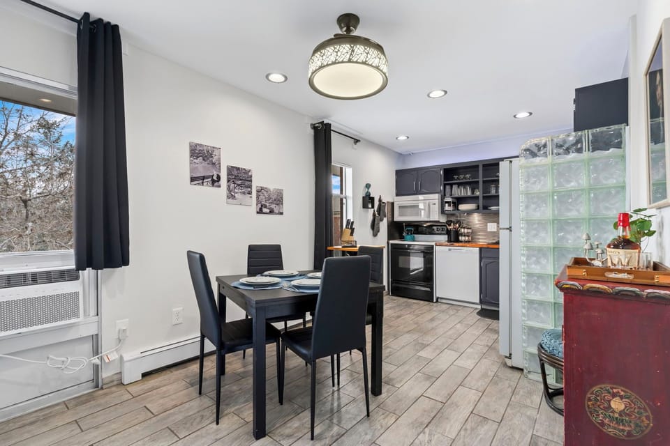 Enjoy meals in your modern open-concept space with sleek kitchen, stylish dining table, and natural light streaming through large windows.