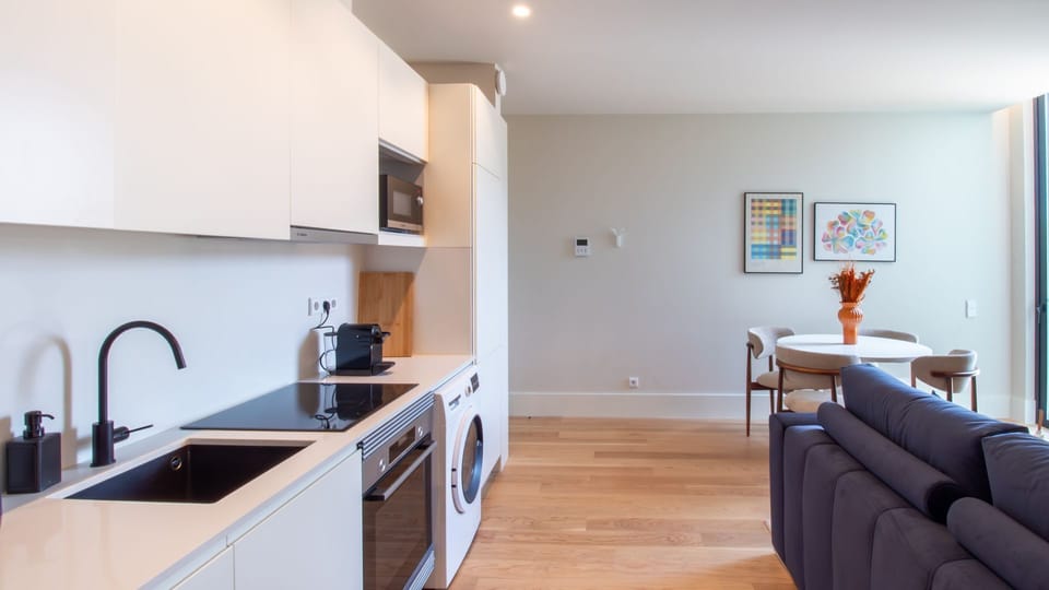 Contemporary open-plan kitchen and living area featuring premium appliances and designer furnishings for a stylish city escape.
#OpenPlanLiving #PortoDuplex #ModernKitchen #StayInStyle