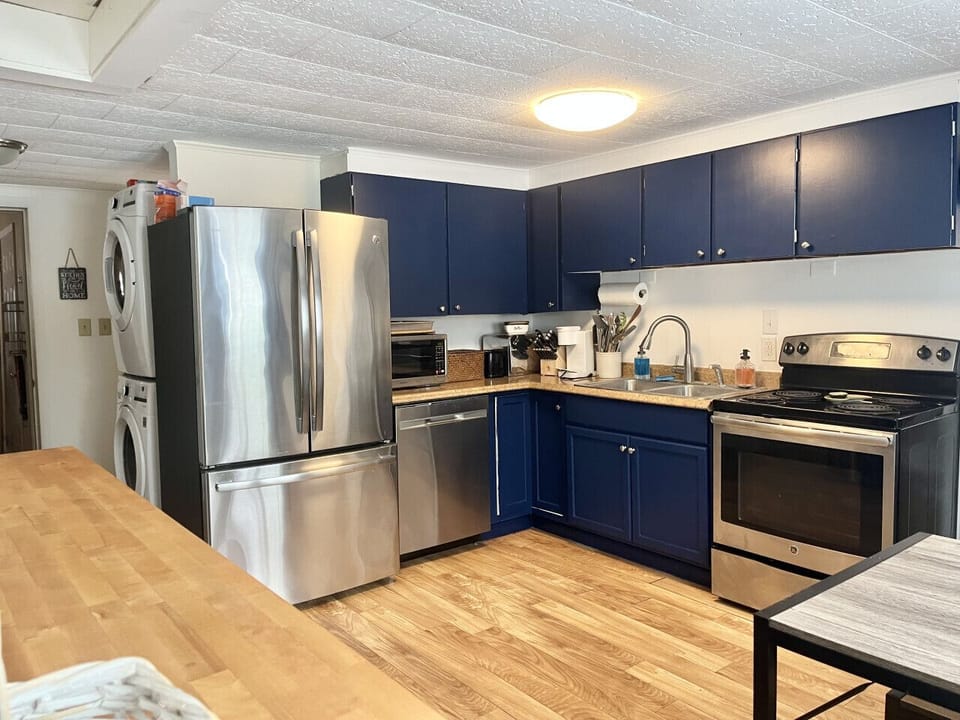 Surrounding the fireplace is an open-concept layout where the living room, kitchen, and dining area flow together seamlessly, allowing for easy connection and conversation.