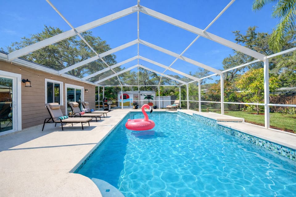 A stunning full-length view of the private screened pool with serene wooded surroundings, offering both privacy and a peaceful retreat.