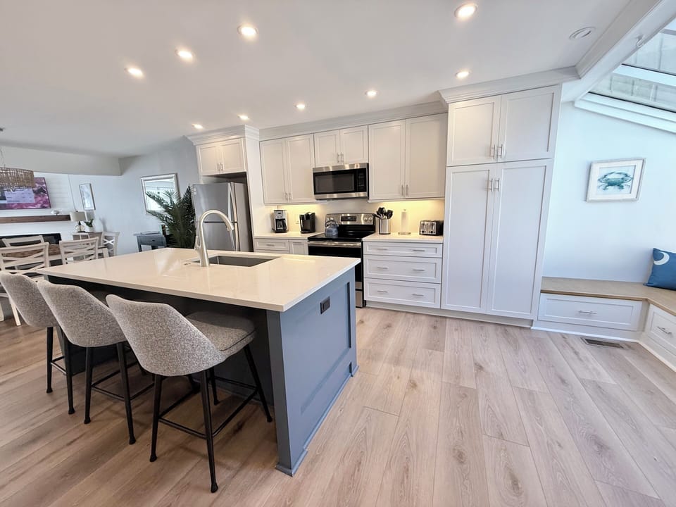 A large island with comfy seating anchors this fully-appointed kitchen