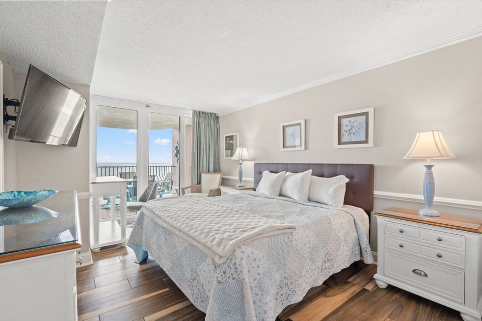 Oceanfront primary bedroom with a king bed, Smart TV, ample clothing storage, and direct balcony access, offering stunning ocean views right from the room.