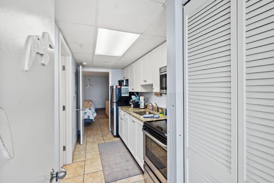 Fully stocked kitchen equipped with major appliances including refrigerator, sink, microwave, stove, and oven. Enjoy both a Keurig and drip coffee maker, making meals and morning coffee easy during your Myrtle Beach stay.