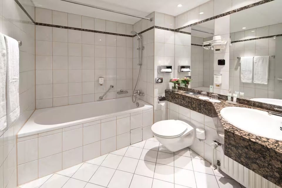 Unwind in a spotless bath with fresh towels and bright lighting.