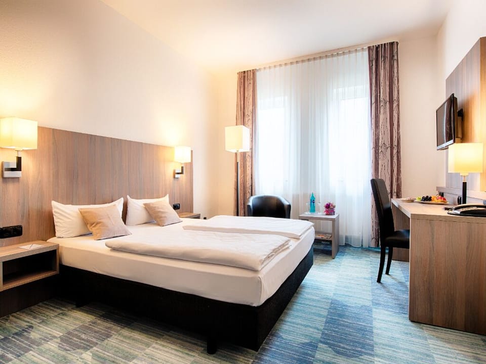 Relax in a bright, modern room with plush, inviting bedding.