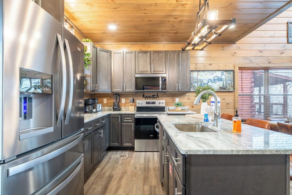 Cook your favorite meals in this fully equipped modern kitchen with granite counters, stainless appliances, and warm wood accents.