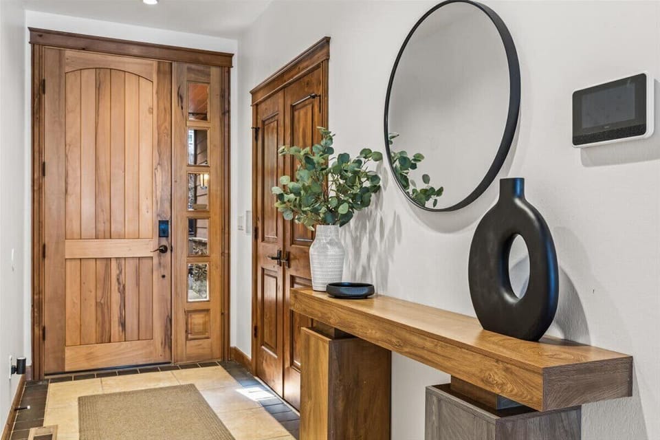 Welcoming entry with solid knotty-alder door, console table, and smart-home panel