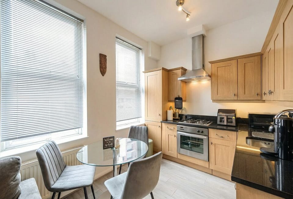 Kitchen and dining nook glowing in warm afternoon light with full cooking appliances.