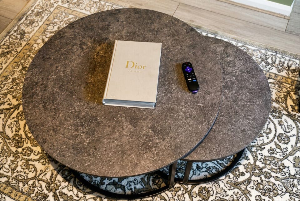 Marble-effect nesting tables with a Dior coffee table book for leisurely browsing.