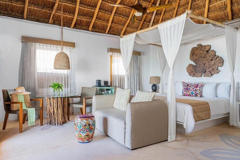 Unwind in your airy suite with canopy bed and lounge.