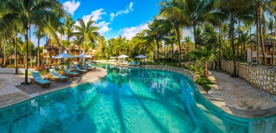 Stretch out along the winding pool framed by palms and stonework.