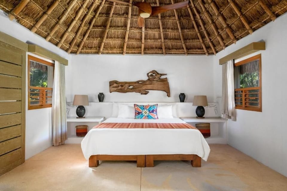 Sink into a serene king bed under a dreamy palapa ceiling.