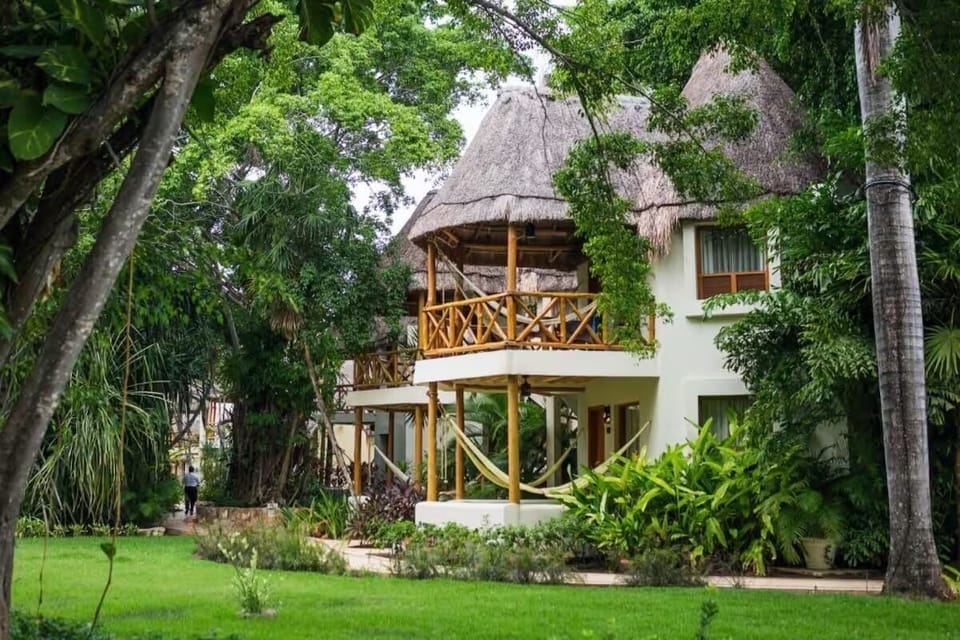 Discover your tropical villa nestled in vibrant, shady gardens.