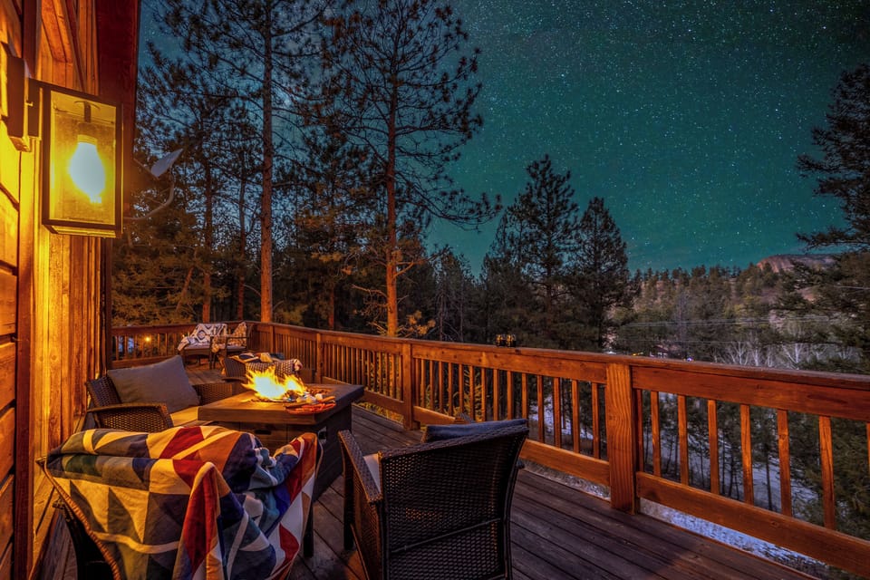 ✨🔥 Starry-night magic on the deck—snuggle up under blankets, sip something warm, and gather around the fire table with mountain air all around 🌌🌲