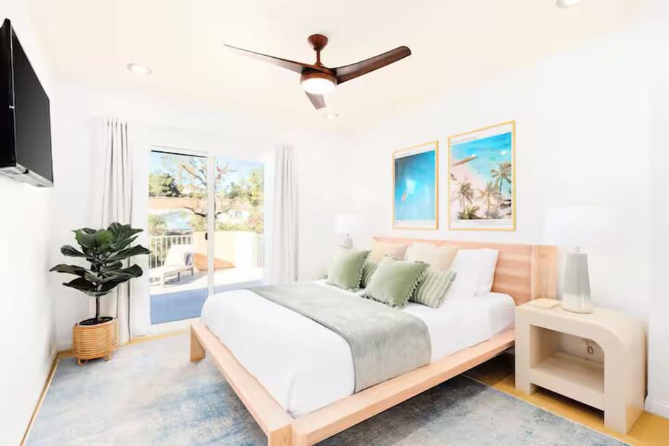 This queen bedroom evokes coral and emerald green hues, capturing coastal tranquility and beach waves. Perfect for a restful night’s sleep, just steps from Del Mar Beach.
