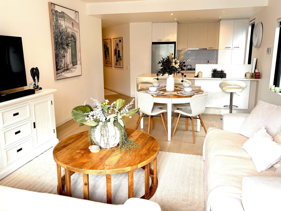 The open plan living/dining room. Kitchen with bench seating in background